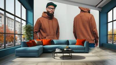 Handsome hipster guy with beard wearing brown blank hoodie or hoody from front and back and black cap with space for your logo or design on white background. Mockup for print Wall mural