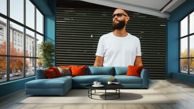 Young bearded hipster guy wearing white blank t-shirt and blue jeans in a random urban style. Design men t shirt mock-up for print Wall mural