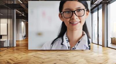 Doctor, happy and face in office for healthcare, confidence and medical services with glasses. Woman, portrait and smile in hospital for health, wellness and cardiology with medicine and stethoscope Wall mural