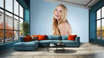 Woman, happiness and hair care in blue background for cosmetics with volume, confidence and trendy style. Female person, growth and shine in isolated, keratin or texture for beauty in studio backdrop Wall mural