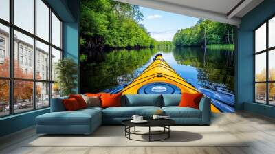 A kayak paddling through a peaceful river, with trees reflecting in the calm water under the summer sun Wall mural