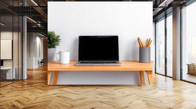 A minimalist desk with a laptop and coffee mug, set against a white wall with nothing but essentials for work Wall mural