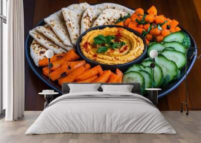 A vegan snack platter with hummus, pita bread, and raw vegetables, showcasing the healthy and delicious snacks available in vegan eating Wall mural