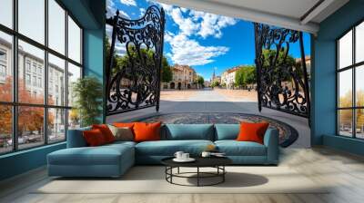 A wrought iron gate leading into a historical town square, the gate beautifully adorned with patterns reflecting the town's history Wall mural