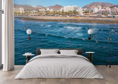 Aerial photo from drone to de surfers in the ocean beachs Adeje Playa de las Americas, Playa Honda In the background Tenerife at sunset. Tenerife, Canary islands, Spain Wall mural