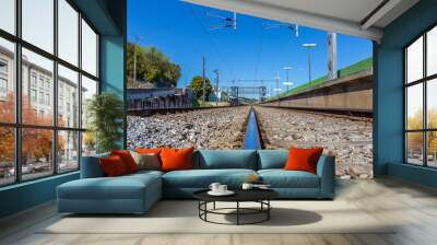 Train Rail Road's Leading to a Train Station under a Pale Blue Sky Wall mural