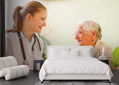 a caring doctor and an elderly sick woman talking Wall mural