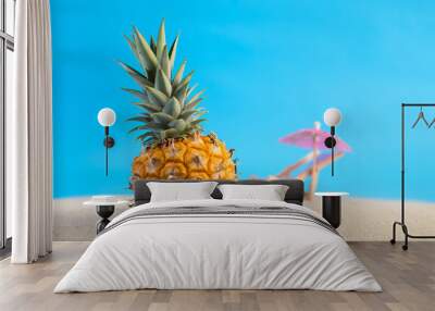 Pineapple on sea sand with blue background. Summer background. Wall mural