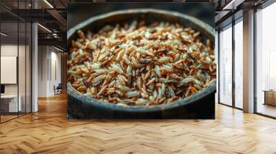 A rustic bowl filled with a mixture of brown and white rice grains, slightly mashed and dehydrated, with a few stray grains scattered around, emitting a warm, earthy aroma. Wall mural