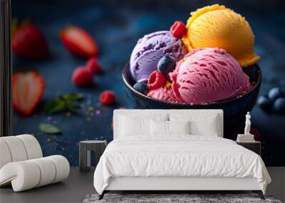 Creative food concept. Scoop balls of colourful gelato sorbet ice cream in black bowl on dark concrete background with scattered raspberry blueberries strawberry fruits. copy text space Wall mural