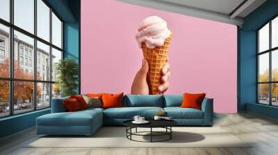 Hand holding ice cream cone on pink background. Banner, advertisement Wall mural