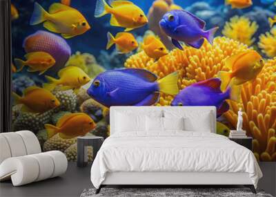 Vibrant orange and blue damsel fish swim alongside yellow and purple tangs in a coral reef, showcasing their intricate scales and flowing fins. Wall mural