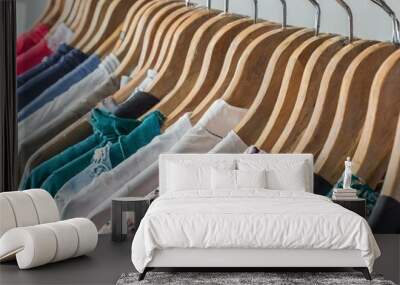 rows of hangers with colorful clothes closeup for retail inside a shopping store and at home Wall mural