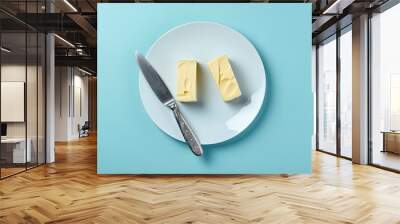 top view of butter and knife on white plate on blue background Generated AI Wall mural