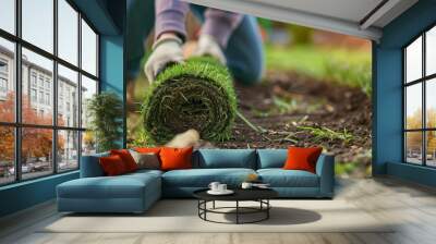 A landscaper works with rolled sod, hands visible, and a close-up of the grass roll Wall mural