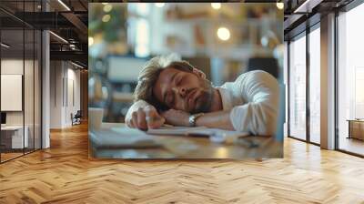 Man sleeps on desk with head on laptop Wall mural