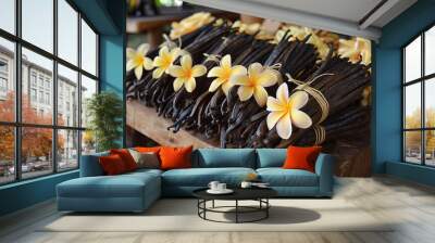 vanilla pods adorned with yellow plumeria flowers on table Wall mural