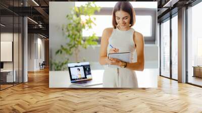 Young Professional Woman Taking Notes in Modern Workspace Wall mural