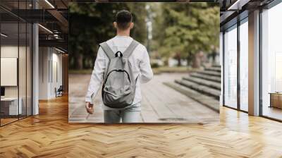 Young student going to university. Shot from behind. Wall mural