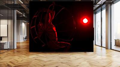 silhouette of sexy woman in red light on a dark background. leggy woman in a bodysuit with metal rings Wall mural