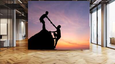 Teamwork couple hiking help each other trust assistance silhouette in mountains, sunset. Teamwork of man to success Wall mural