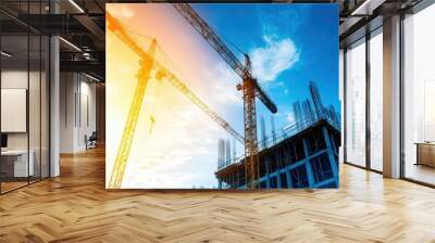 A construction site with two cranes and a building in the background Wall mural