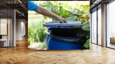 Closeup hand hold lid to cover water bucket to protect from mosquito to breed inside or other  insects or dust go into water. Concept, campaign to stop mosquitoes cycle to lay eggs in water container  Wall mural