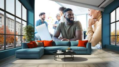 A male and a female employees discussing a new coarse of their business with three more employees in the background, holding the candle. Wall mural