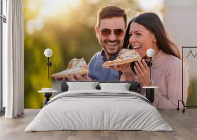 Picture of happy young couple eating pizza Wall mural