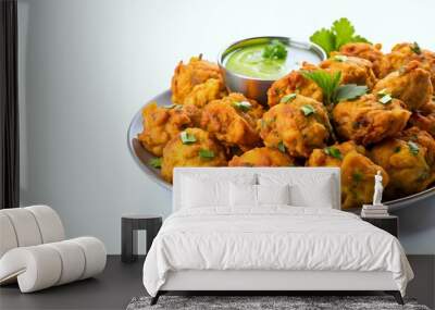 A plate of delicious Indian snack called pakora is served on white background Wall mural