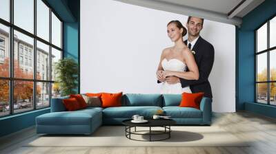 Beautiful bride and groom smiling in studio, portrait Wall mural