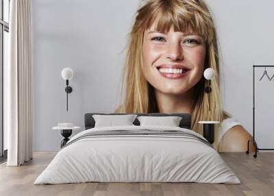 Lovely young woman smiling in studio Wall mural