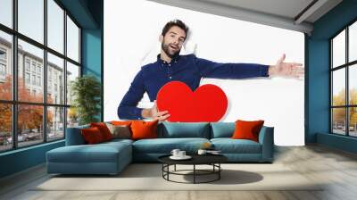 Man declaring love with heart in studio Wall mural