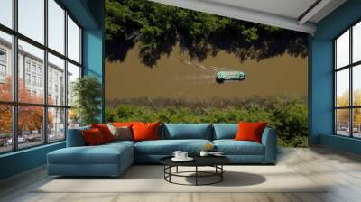 Top down view of cargo ship in narrow steam, sunny day and rainforest Wall mural