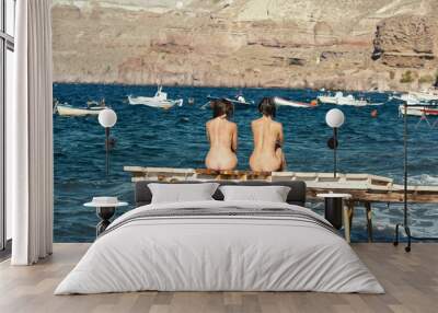 Two women sitting on pier Wall mural