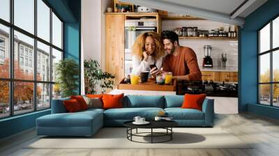 Couple having breakfast in kitchen. Wall mural