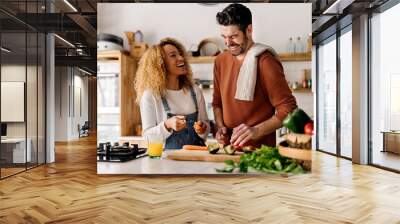 Couple preparing food in kitchen. Wall mural