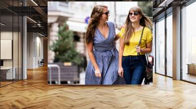 Stylish young women walking in the street Wall mural