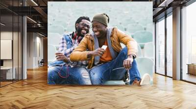 Two black race friends having fun with mobile. Wall mural