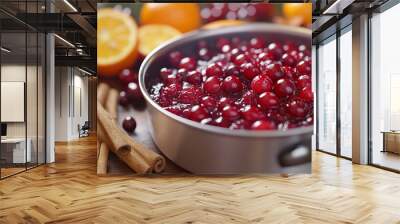 Preparing Christmas cranberry sauce in a saucepan, with fresh cranberries, oranges, and cinnamon sticks on the side. 4K hyperrealistic photo. Wall mural