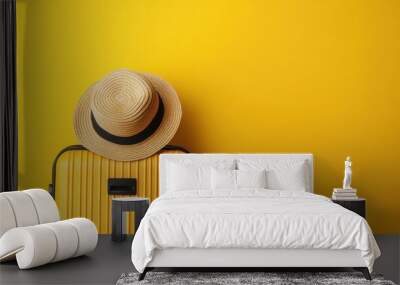 Travel Concept. Hand luggage suitcase with hat on it over yellow studio background with copy space Wall mural