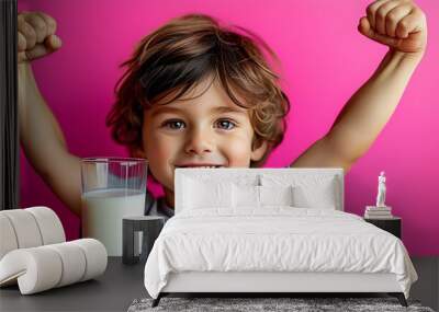 Cheerful boy flexing muscle with glass of milk on vibrant pink backdrop, embodying health and fitness themes Wall mural