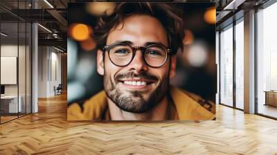 Cheerful man in glasses smiling warmly at the camera Wall mural