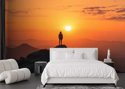 Contemplative silhouette against a vibrant sunset sky from a breathtaking mountaintop view Wall mural