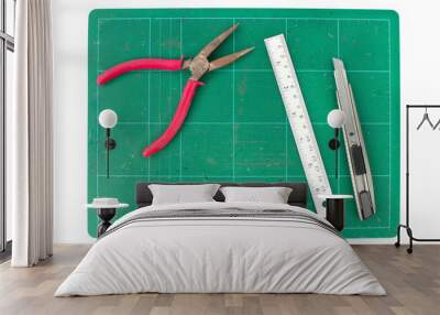 Green cutting mats with iron ruler pliers and cuter on white bac Wall mural