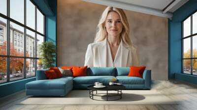 Senior Caucasian female executive with blonde hair, wearing a cream blazer, standing at a conference table in a boardroom with modern interior design. Tech, professional digital information work Wall mural