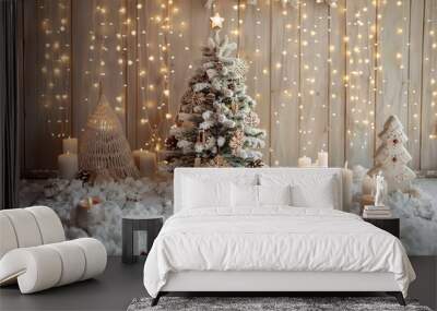 Wooden wall with Christmas decorations, a small white Christmas tree and gingerbread cookies, candles on the snowy floor, light garlands hanging from above on a wooden background Wall mural