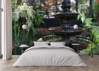 Classic vintage fountain in shady garden. Wall mural