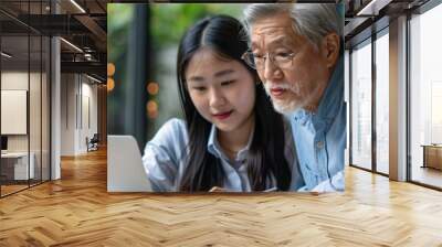 A mid-aged Latin male manager mentors a young Asian female worker, fostering teamwork and corporate strategy development in an international team meeting Wall mural