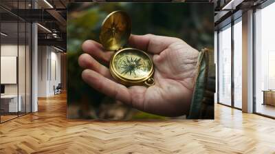 Hand Holding a Compass: A hand holding a brass compass, evoking a sense of adventure and direction.
 Wall mural